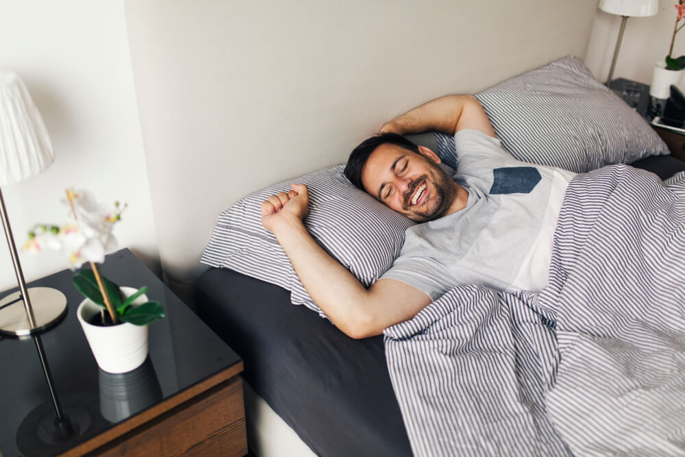 Imagem de um homem acordando feliz.