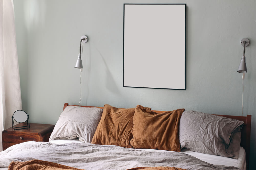 um quarto com uma cama, duas luminárias e um quadro na parede