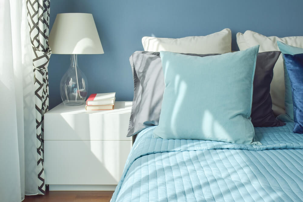 uma cama com edredom e travesseiros azuis