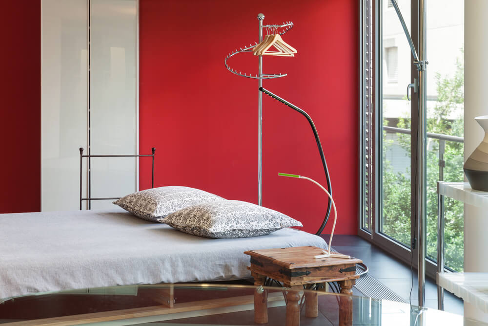 uma cama em um quarto com parede vermelha