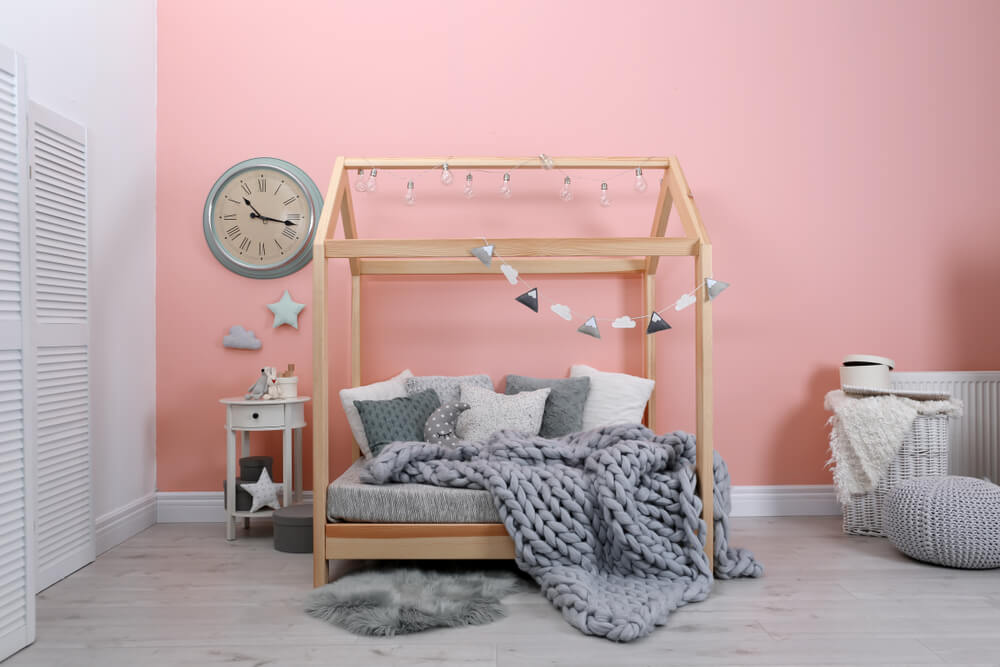 um quarto com paredes rosa e uma cama de dossel