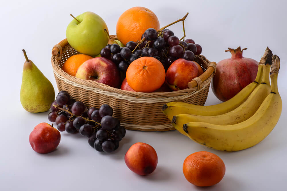 uma cesta de vime cheia de muitas frutas