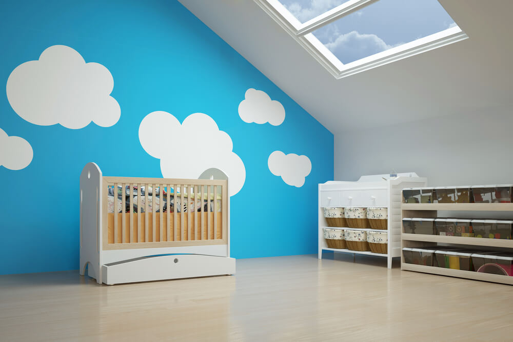 quarto de bebê com clarabóia e nuvens pintadas na parede