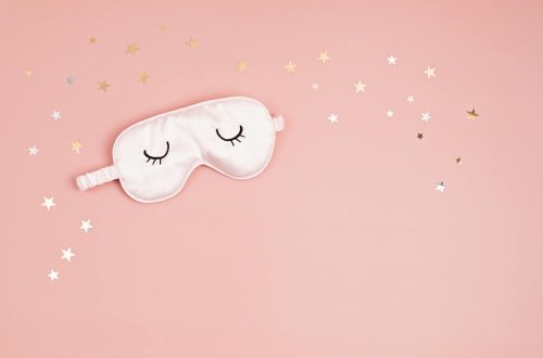 Imagem de uma máscara de dormir sob um fundo rosa.
