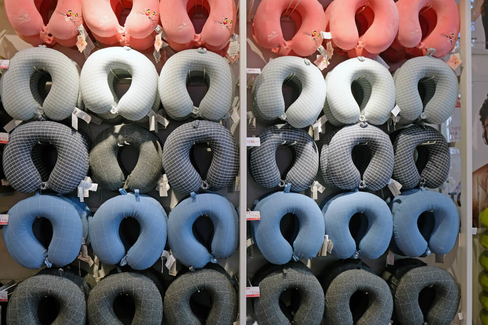 Imagem de vários travesseiros de pescoço de cores diferentes.