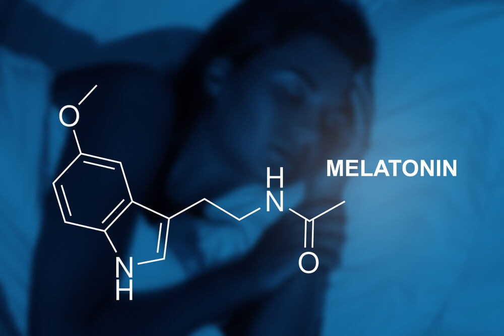 Imagem de uma mulher dormindo. Na imagem, há o desenho da fórmula da melatonina, conhecida como hormônio do sono.