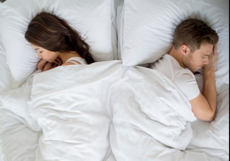 um homem e uma mulher deitados na cama juntos