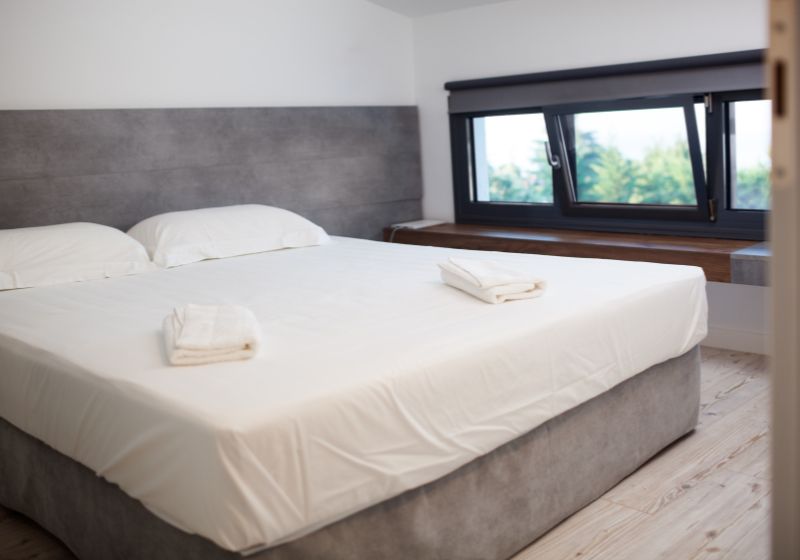 uma cama com lençóis brancos e travesseiros em um quarto