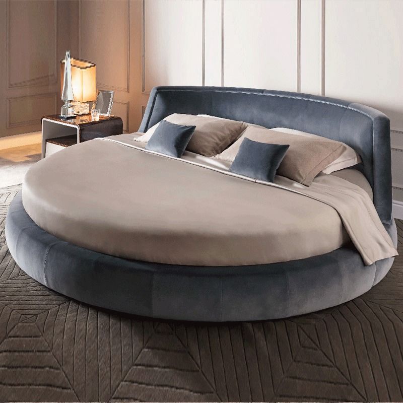 uma cama redonda com travesseiros e almofadas em cima