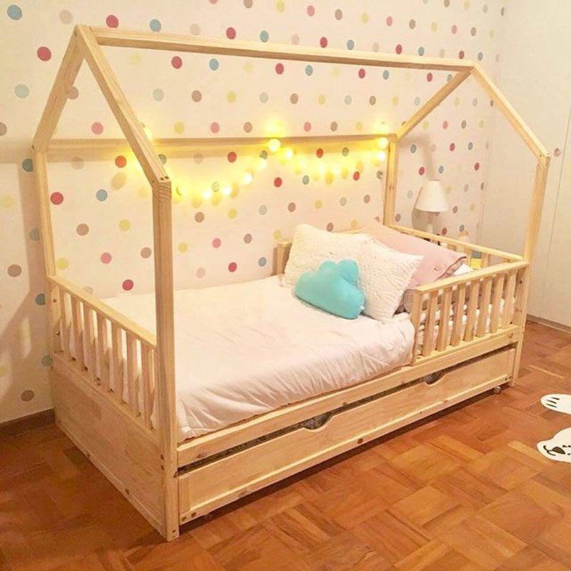 cama de criança em quarto com papel de parede de bolinhas