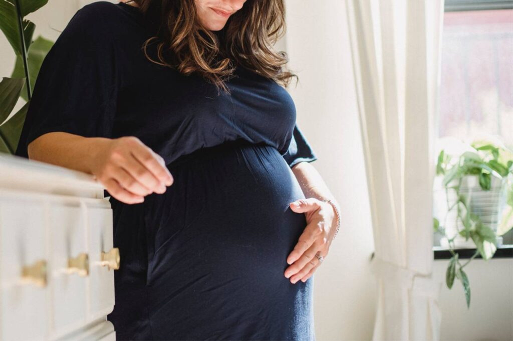 mulher grávida com a mão na barriga