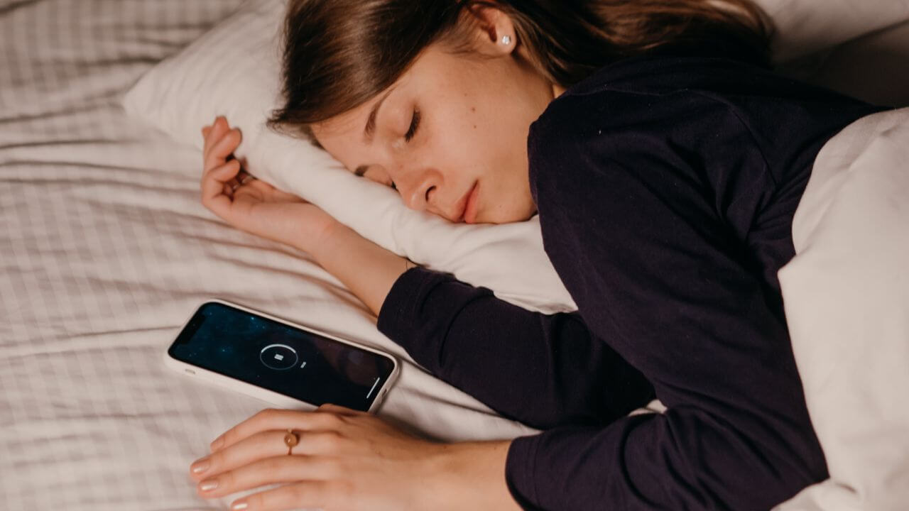 mulher dormindo com celular tocando ruído branco